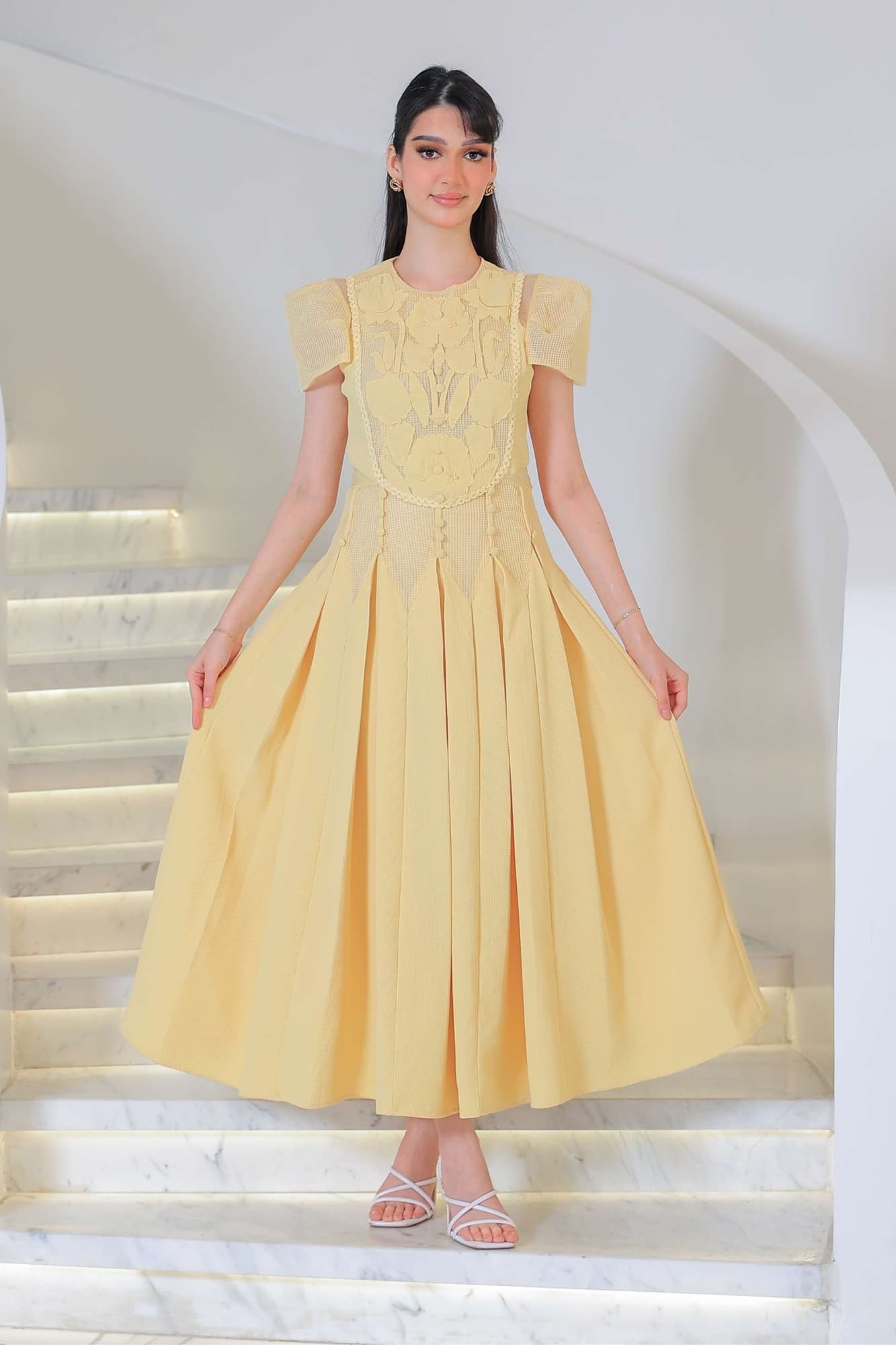 فستان أنيق بطابع ناعم وأنثوي يتميز بتفاصيل دانتيل وزخارف بارزة