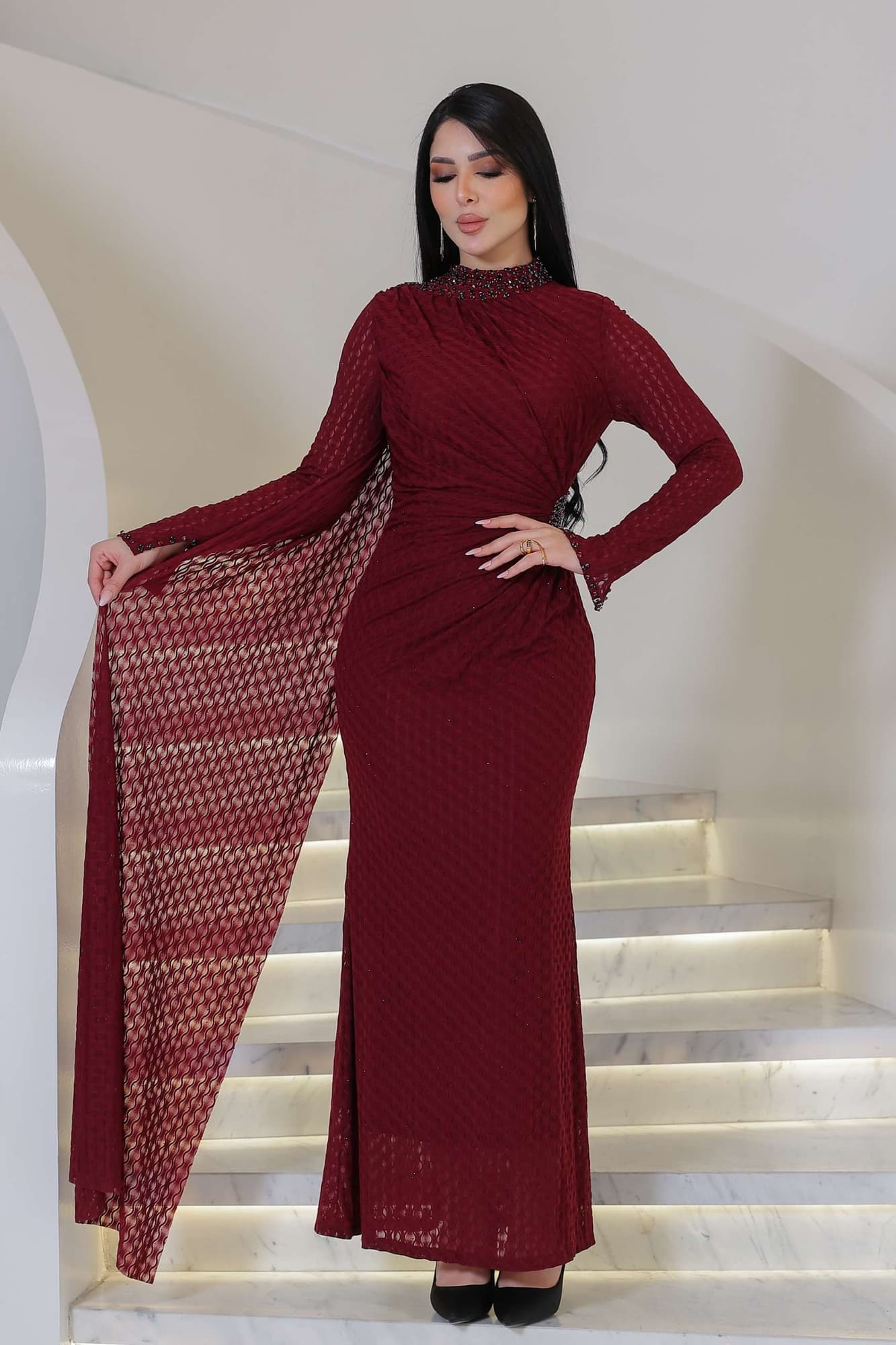 فستان ناعم راقٍ يتميّز بياقة عالية مزينة بتطريز خرزي ناعم يضفي لمسة ملكية