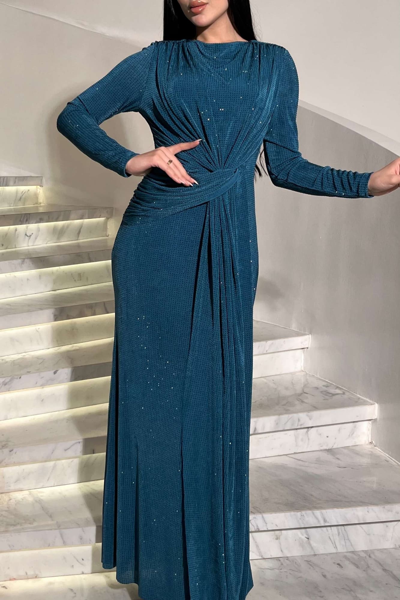 فستان ناعم طويل مصنوع من قماش ناعم بلمعة خفيفة تمنح إطلالة أنيقة وراقية