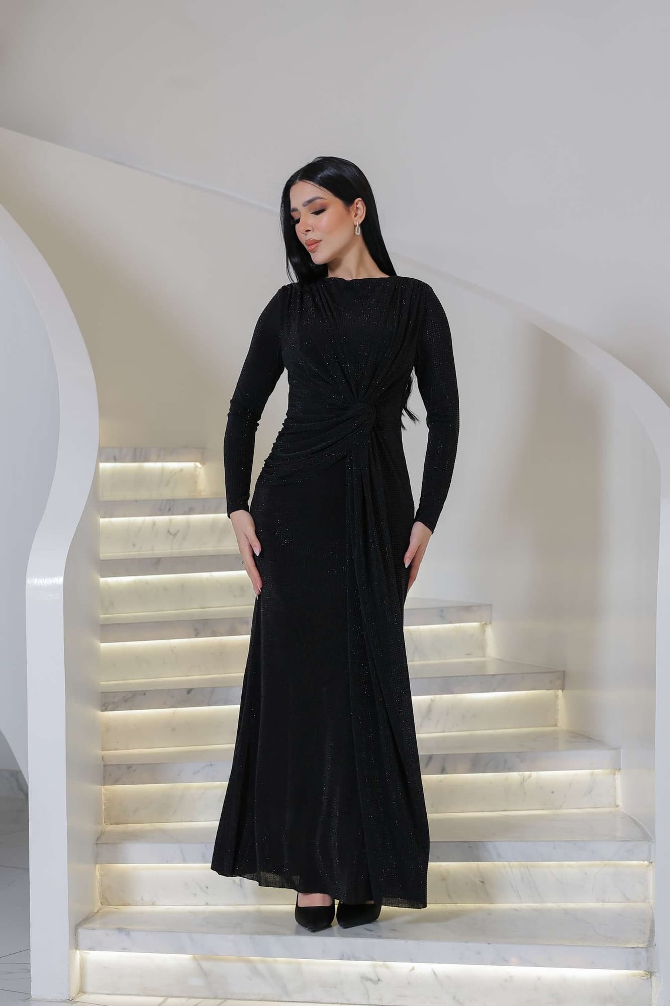 فستان ناعم طويل مصنوع من قماش ناعم بلمعة خفيفة تمنح إطلالة أنيقة وراقية