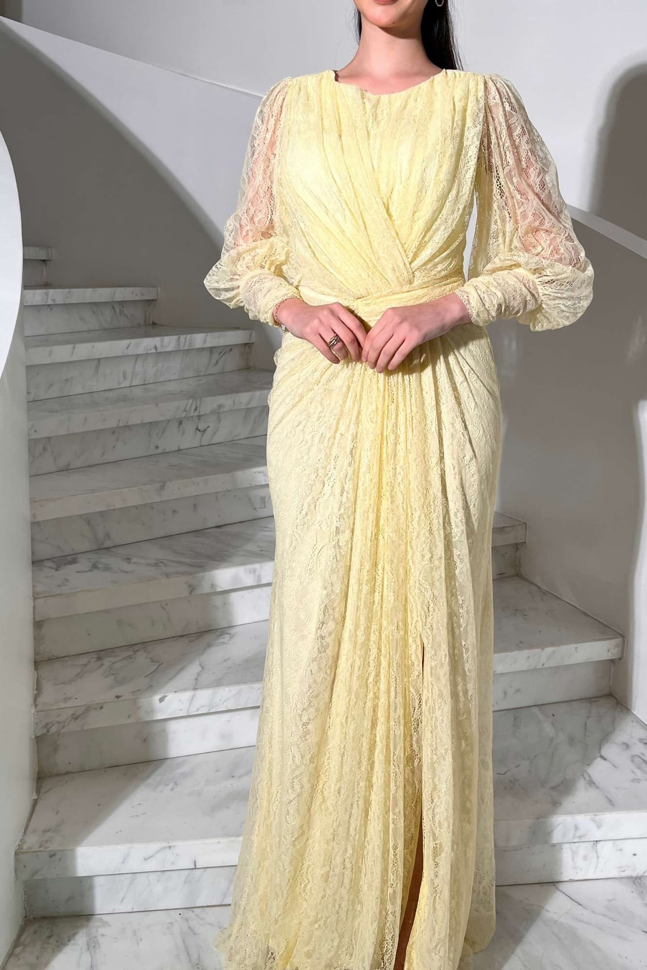 فستان دانتيل طويل يتميز بتفاصيل draping ملتفة حول منطقة الخصر تنحت الجسم بأسلوب أنثوي