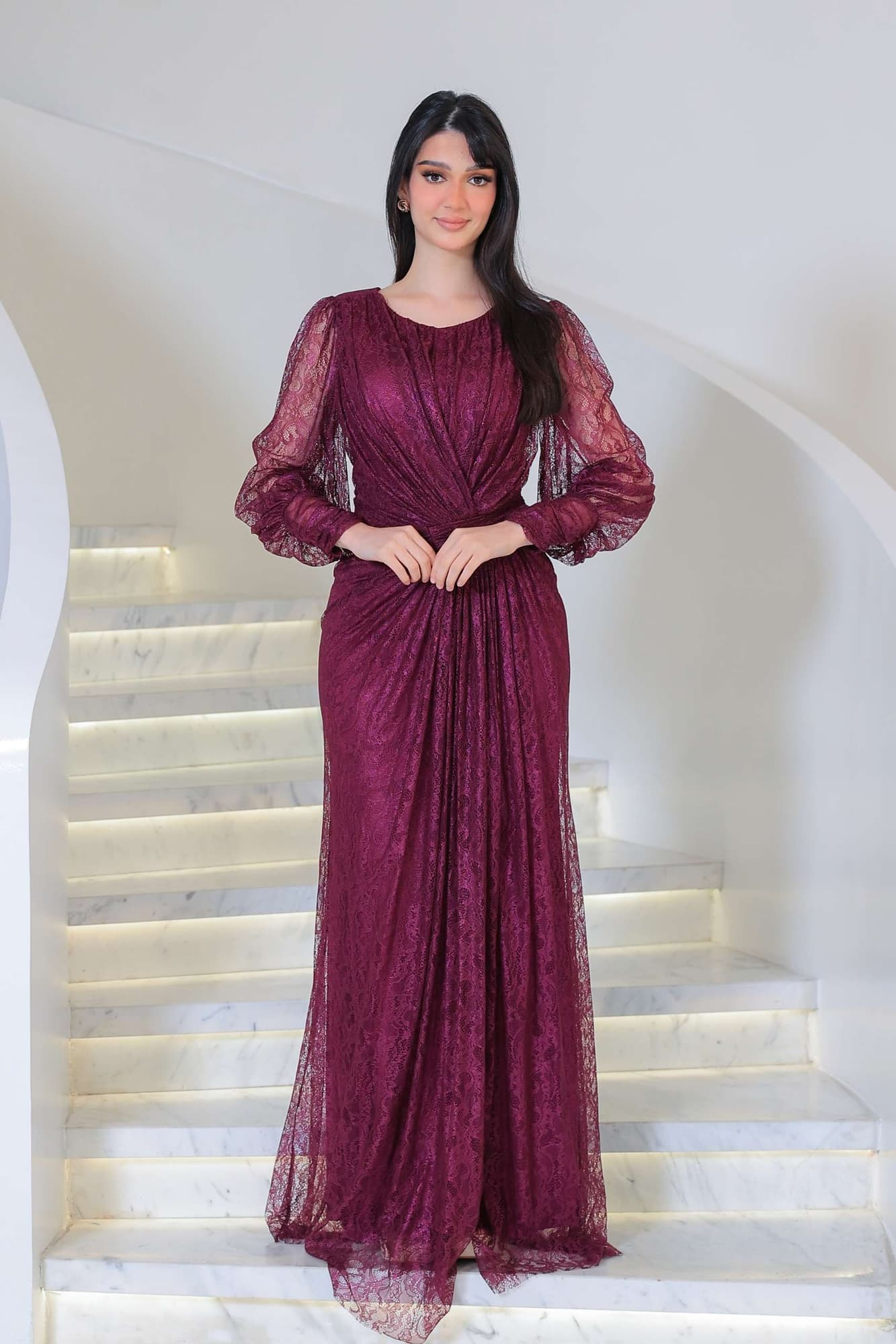 فستان دانتيل طويل يتميز بتفاصيل draping ملتفة حول منطقة الخصر تنحت الجسم بأسلوب أنثوي