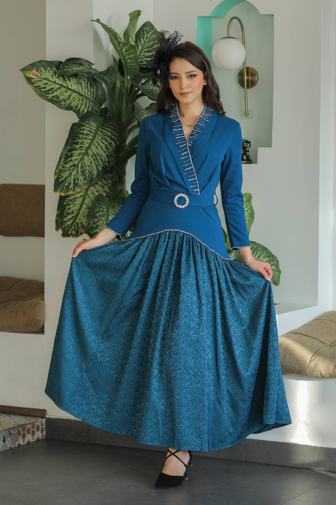 فستان راقٍ بلون أخضر زمردي عميق يجمع بين الكلاسيكية والفخامة بأسلوب عصري