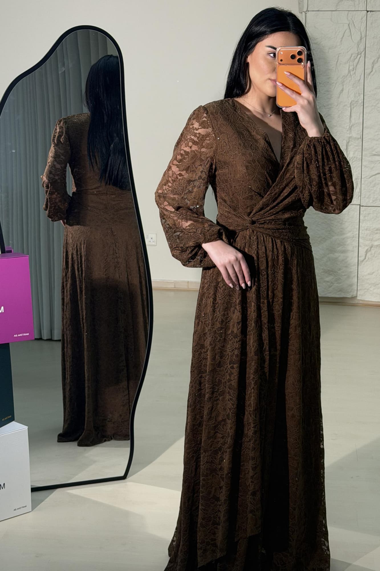 فستان طويل من الدانتيل يعكس أنوثة راقية ولمسة رومانسية ناعمة يتميّز بقصّة لفّ (Wrap) أنيقة مع عقدة جانبية تبرز الخصر