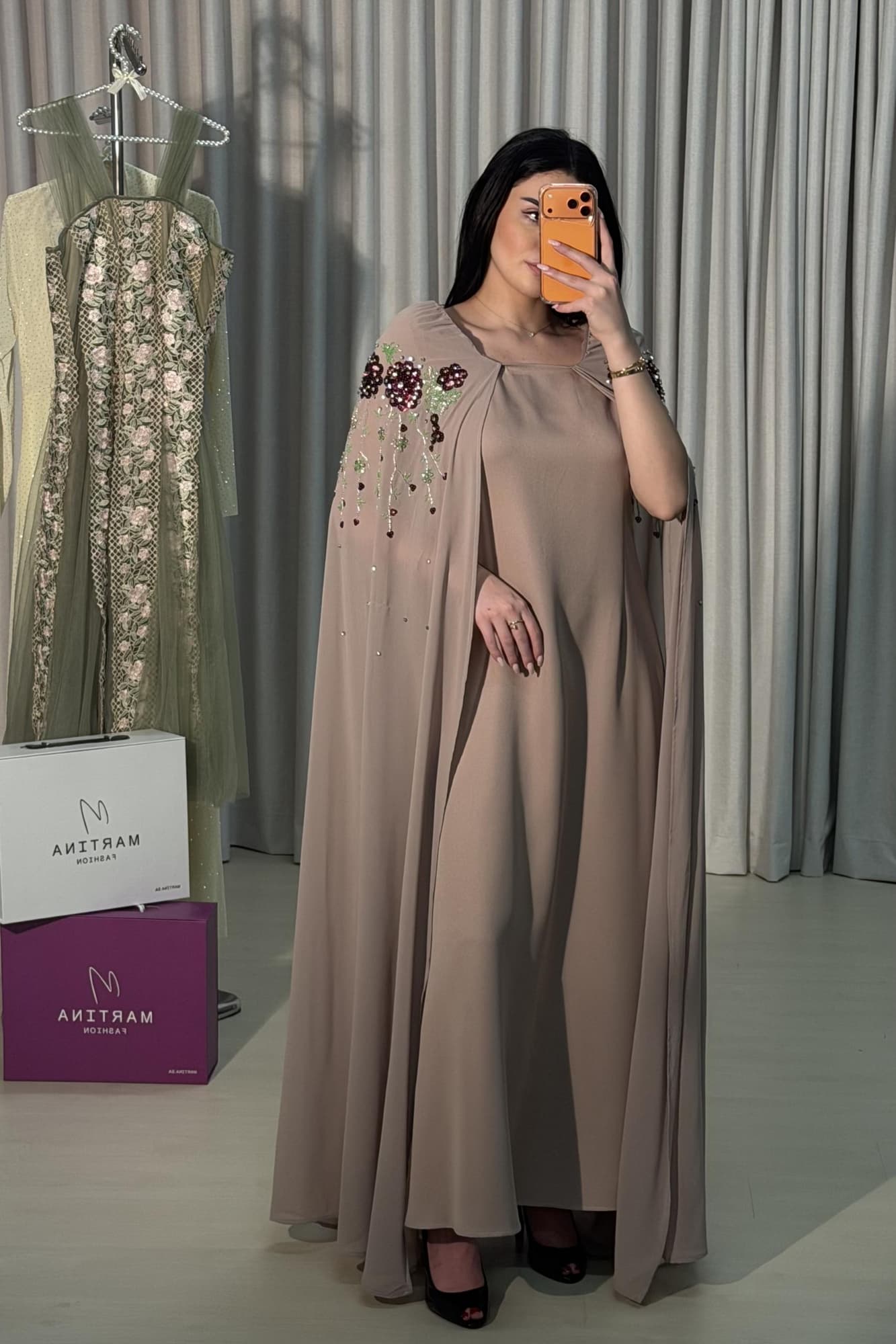 جلابية فخمة بتصميم هادئ تتميز بقصة واسعة كلاسيكية مع أكمام كاب طويلة تنساب بحرية